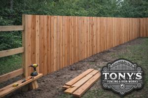 Custom cedar privacy fence being built board-by-board during installation by Tony’s Fencing & Iron Works in Southeast Louisiana, showing the difference between built fences and pre-made panels.