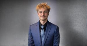 Professional headshot of Jesse Knight wearing a blue suit and patterned tie against a gray background for team expansion highlight.