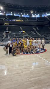 Women’s basketball players and event participants posing together on the court at Intuit Dome during the Ballin’ 4 Peace event.