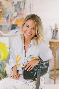 Headshot of artist and entrepreneur Jodie King seated on a chair, smiling toward the camera.”