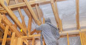 Technician insulating an attic using foam base