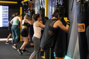 Mujeres realizando una sesión de fitboxing rítmico en un saco de Brooklyn Fitboxing como parte del programa de recuperación emocional Own Your Strength.