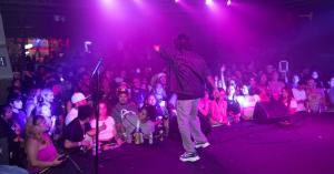 Audience with hands up or phones raised during a hook moment