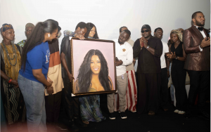 SLUM2School volunteers and students present a drawing to Omotola Jalade-Ekiende