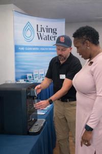 Steve Stiles of RO Living Water pours purified drinking water from a touchless reverse osmosis dispenser during a product demonstration for a local business owner in Novato.