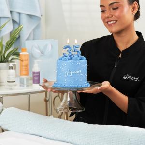 GlyMed+ professional holding a blue birthday cake for GlyMed's 35th anniversary