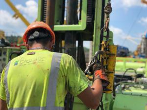 man in hard hat operating sonic drill rig
