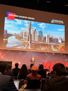 The image shows a moment from a press conference on the stage of the Hannover Messe 2026 event, with a focus on the event's CEO, Jochen Köckler. He is positioned at the center, standing in front of a backdrop featuring banners and logos related to the eve