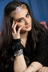 Close-up portrait of Tamara Mechael wearing a gold headpiece and artistic makeup