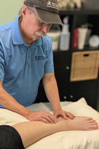 Therapist assessing scar tissue on a healed ankle following fibula surgery