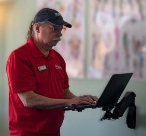 Therapist reviewing patient information on a laptop in a clinical setting