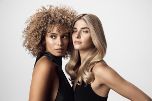 Two models posing to show off their beautiful blonde hair.