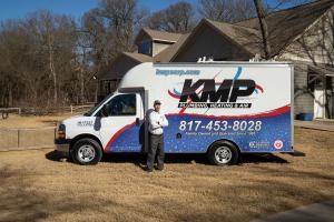 Plumbing Technician standing in front of KMP Service Truck