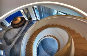 spiral staircase with gradient terrazzo floor in gray tones in the background in luxury residential highrise lobby