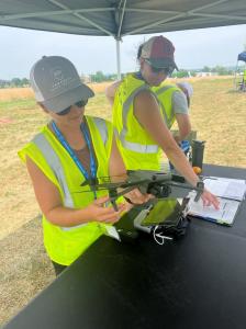 Female student holds quadcopter during pre-flight inspection