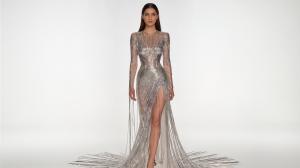 A digital fashion model walks on a virtual runway. She is dressed in a gown made of computer wires, providing a metaphor for digital fashion