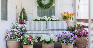 Celestial At Home's Premium Lifelike Outdoor, Waterproof, UV-Protected Florals - Purple and Yellow Petunias, Hot Pink and Light Pink Petunias, White Hydrangeas, Red and White Geraniums, and Boxwoods in traditional terracotta urns on a porch