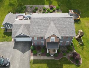 Aerial view of a completed roof replacement on a residential home near Natrona Heights, PA with landscaping and driveway