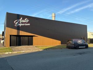 Mobile Sunshine Coast car detailing van parked next to Auto Emporium custom car studio