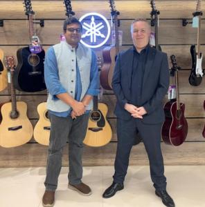 Two men standing in front of musical instruments