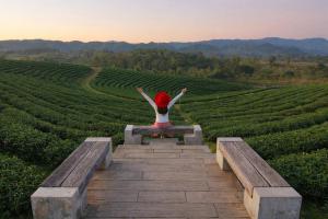 person sitting on a bench overlooking a calm natural landscape representing residential rehab environment