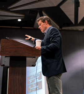 Andrew Geesbreght, Co-Founder of PRAX Performance, speaking at a podium during the Association of Chief Executives of Sport Conference in Fort Worth, TX.