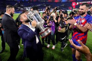 a man kissing a trophy after winning
