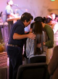 Pastor praying with congregation members during a worship service at Calvary Chapel The Rock in Santa Rosa California