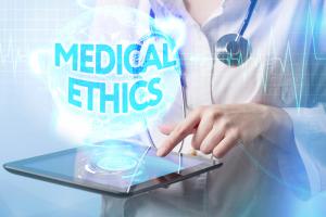 health professional on table device with words medical ethics near the tablet