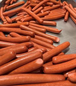 Assortment of links of the big-format snap-o-razzo big sexy hot dog on a metal holding tray