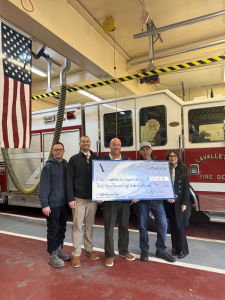 Volunteer firefighter Chris Marino presents the check to the Lavallette Fire Department