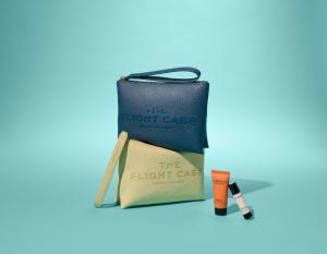 Marc Jacobs premium economy amenity kit with blue and green textured pouches labeled “The Flight Case” and travel-sized skincare items