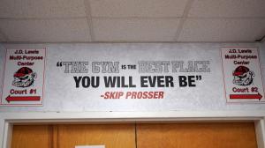 Wayfinding graphic above the gym entrance with a Skip Prosser quote, bulldog logos, and arrows directing visitors to Court #1 and Court #2.
