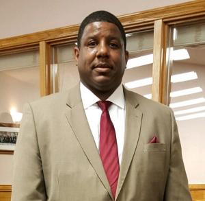 Portrait of Coach Mo wearing a suit and tie.