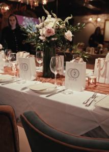 Private Dinner table setup with branded marketing bags, pink flowers, and accessories.