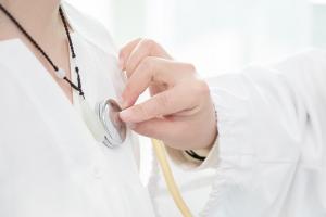 Close-up of a doctor using a stethoscope to examine a patient, representing personalized and preventive primary care services.
