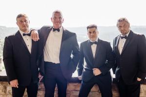 Four men in formal wear standing together, representing professionalism, confidence, and success.