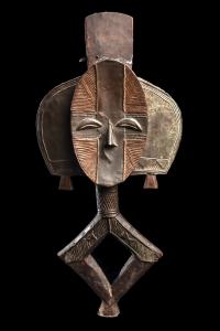 Bakota “Ngulu” (or reliquary garden figure) of abstract figural form, carved from wood with a slender concave face covered with hammered brass alloy sheets in cruciform background. Sold for $7,800