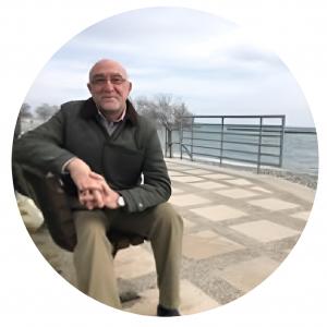 Portrait of author Jafar Redha seated outdoors near a waterfront, known for his book The Truth They Tried to Hide