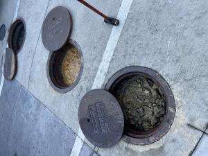 Open grease interceptor being cleaned as part of routine maintenance in a commercial kitchen