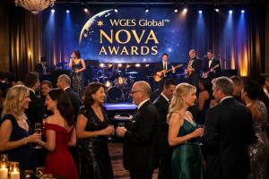 Professionals in formal evening attire networking at WGES Global™ NOVA Awards event with live band and stage presentation in an elegant setting.
