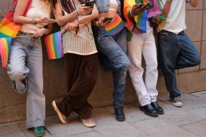 A group of LGBTQIA+ consumers using social media on their phones