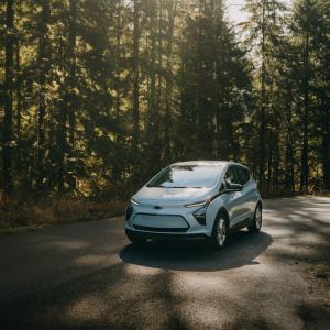 Image of light blue 2023 chevy bolt EV in a nature setting