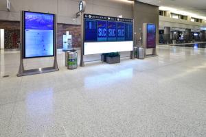neutral terrazzo floor in the concourse of the airport, flight information systems