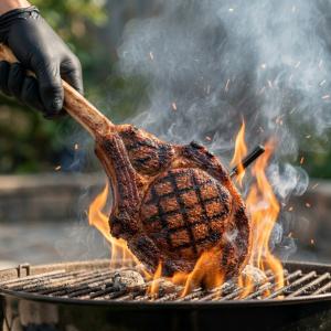 Tomahawk steak grilling over open flame with MeatStick probe inserted, showing high-heat cooking and searing capability.