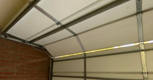 Professional technician performing emergency Pasadena garage door repair on a broken torsion spring.