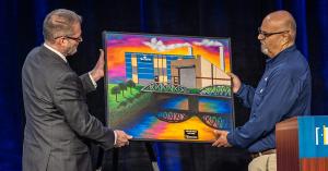 EDC President & CEO Keith Lund presents the 2026 Klaus Thiessen Impact Award painting to Simplot Unit Director David Valdez.