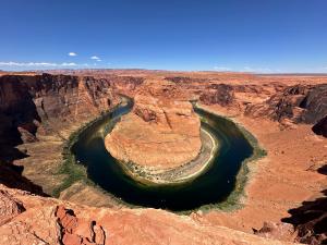 Aerial view of Horseshoe Bend showing the Colorado River curving around a massive rock formation in a desert canyon.