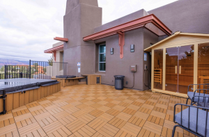 Rooftop patio at Dark Sky Lofts featuring a hot tub, sauna, seating area, and modern architecture with views of Sedona’s red rocks.