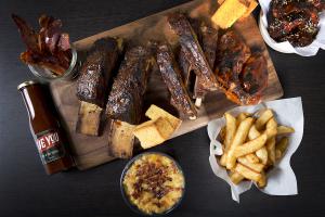 Plate of Delicious smoked meats and fries, with Mac n Cheese and Sauce